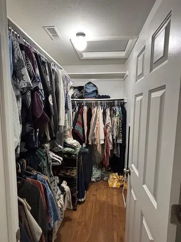 a view of walk in closet with clothes and shoes