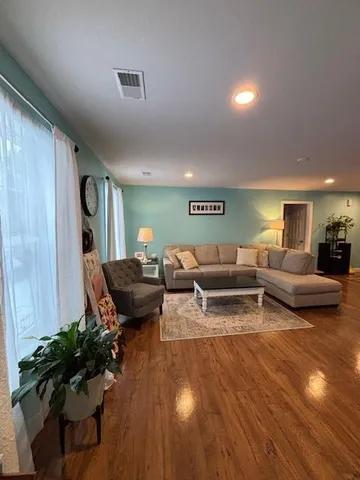 a living room with furniture and wooden floor