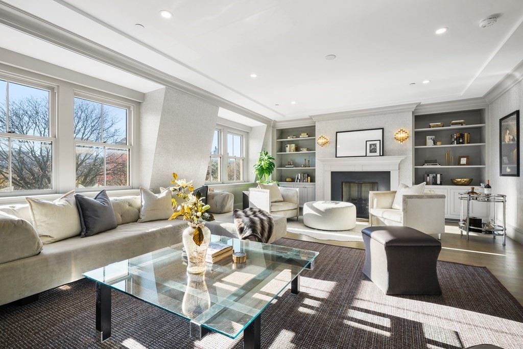 a living room with fireplace furniture and a large window