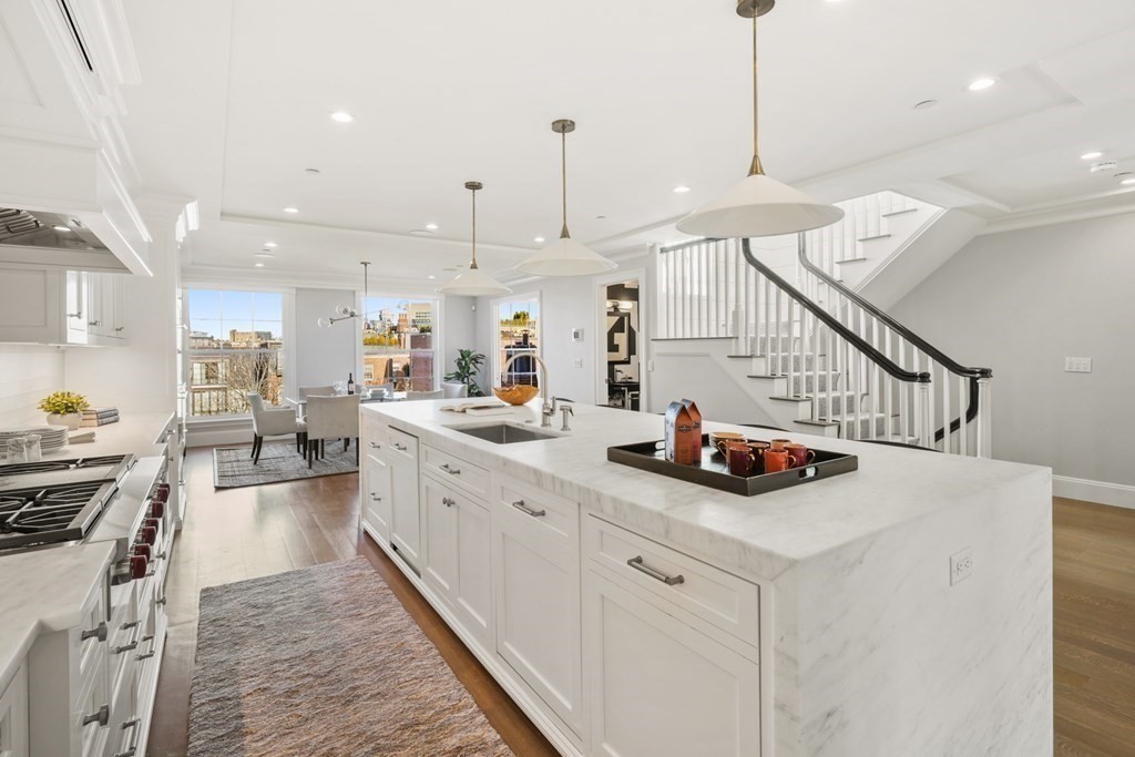 75 Beacon Street, Unit 2 Boston, MA 02108 - Photo 8 of 37 a kitchen with sink stove and white cabinets with wooden floor
