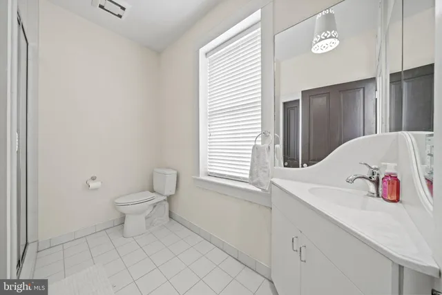 a bathroom with a sink toilet and window