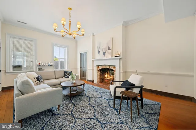 a living room with furniture a fireplace and a chandelier