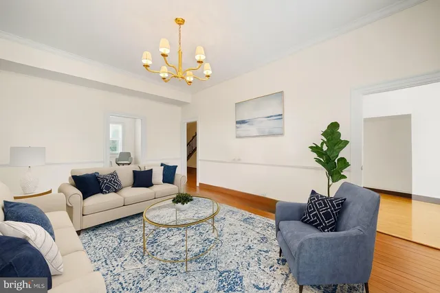 a living room with furniture flowers and a chandelier