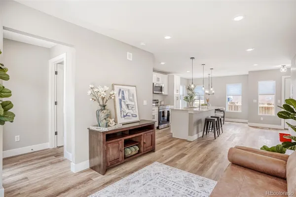 a kitchen with stainless steel appliances kitchen island a table and chairs in it