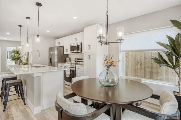 a kitchen with stainless steel appliances kitchen island granite countertop a sink a stove a refrigerator and island with wooden floor