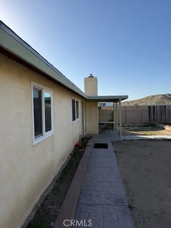 a backyard of a house with wooden floor and brick wall