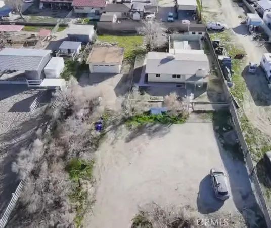 an aerial view of a house with a yard and parking space