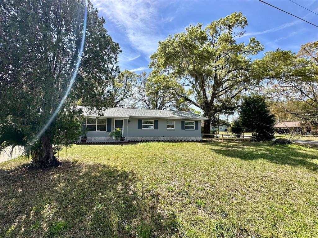 1812 Northeast 50th Street Ocala, FL 34479 - Photo 1 of 15 a view of a house with a big yard and large tree