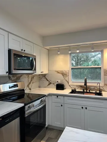 a kitchen with a sink stove and microwave