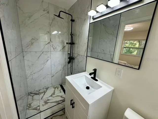 a bathroom with a sink a toilet and shower