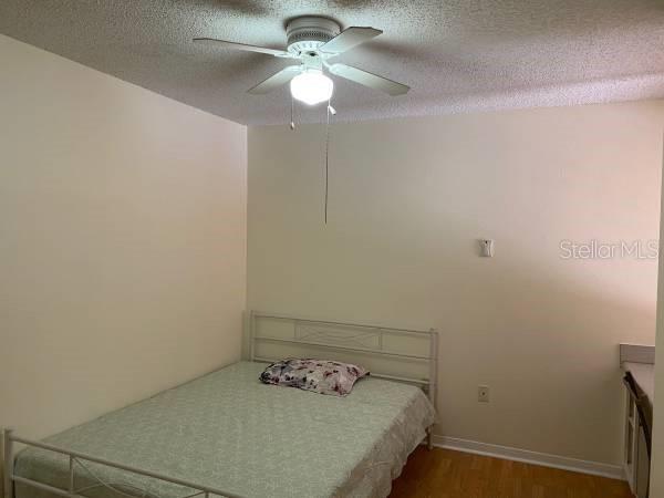 2601 Southwest Archer Road, Unit 321 Gainesville, FL 32608 - Photo 8 of 10 a bedroom with a bed and a chandelier fan