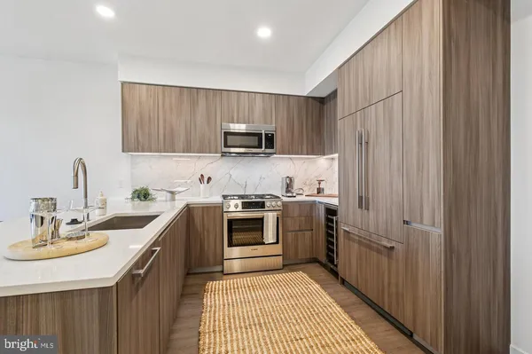 a kitchen with kitchen island a dining table chairs and wooden floor