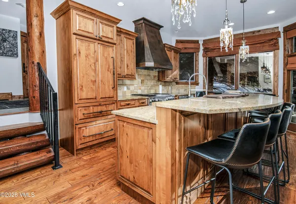 a kitchen with stainless steel appliances granite countertop a sink refrigerator and cabinets