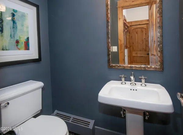 a bathroom with a toilet a sink and mirror