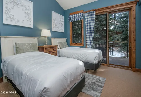 a bedroom with two beds and a large window