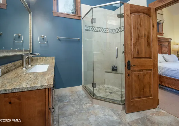a bathroom with a granite countertop shower and a sink
