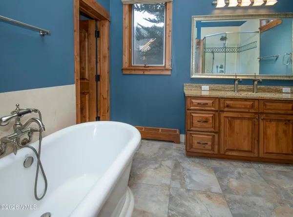 a bathroom with a granite countertop sink a mirror and a bathtub