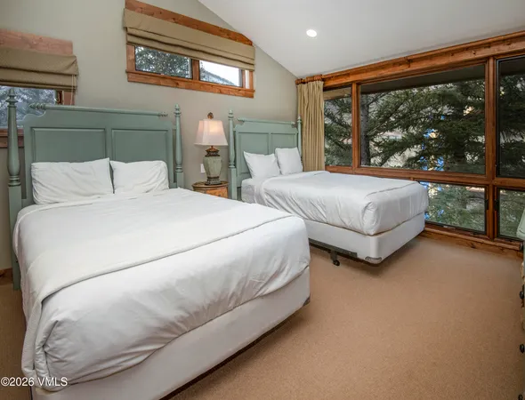 a large bed sitting in a bedroom next to a large window