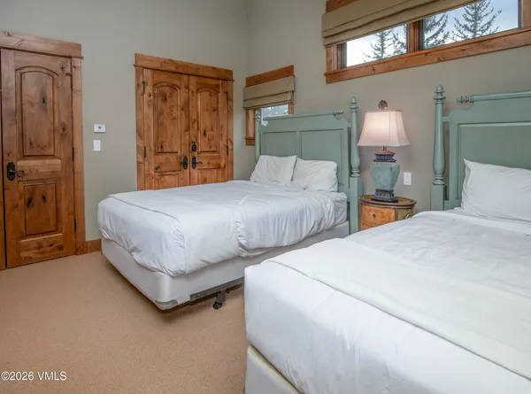 a bedroom with two bed and a lamp