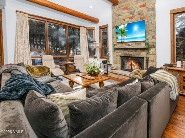 a living room with furniture a floor to ceiling window and a flat screen tv