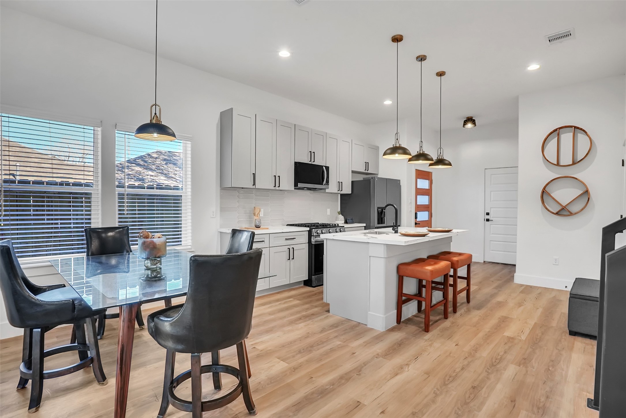 8012 Brandon Street Houston, TX 77051 - Photo 5 of 29 a kitchen with stainless steel appliances granite countertop a stove top oven a refrigerator a sink dishwasher a dining table and chairs with wooden floor