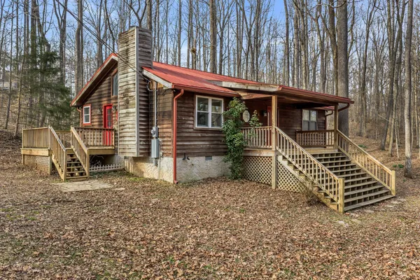 a view of a house with a small deck and a floor to ceiling window