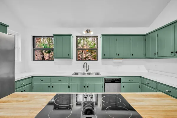a kitchen with a sink and a view of living room