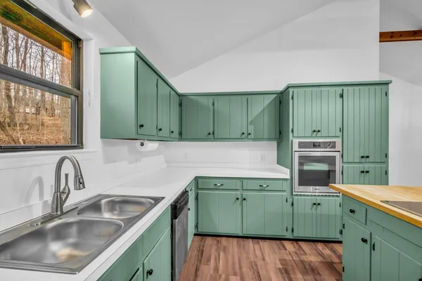 a kitchen with a sink a microwave and cabinets