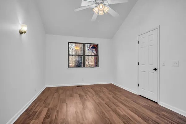 a view of empty room with wooden floor