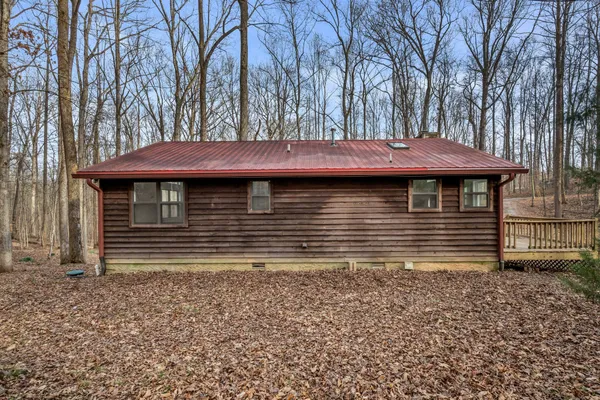 a view of a house with a small yard and large tree