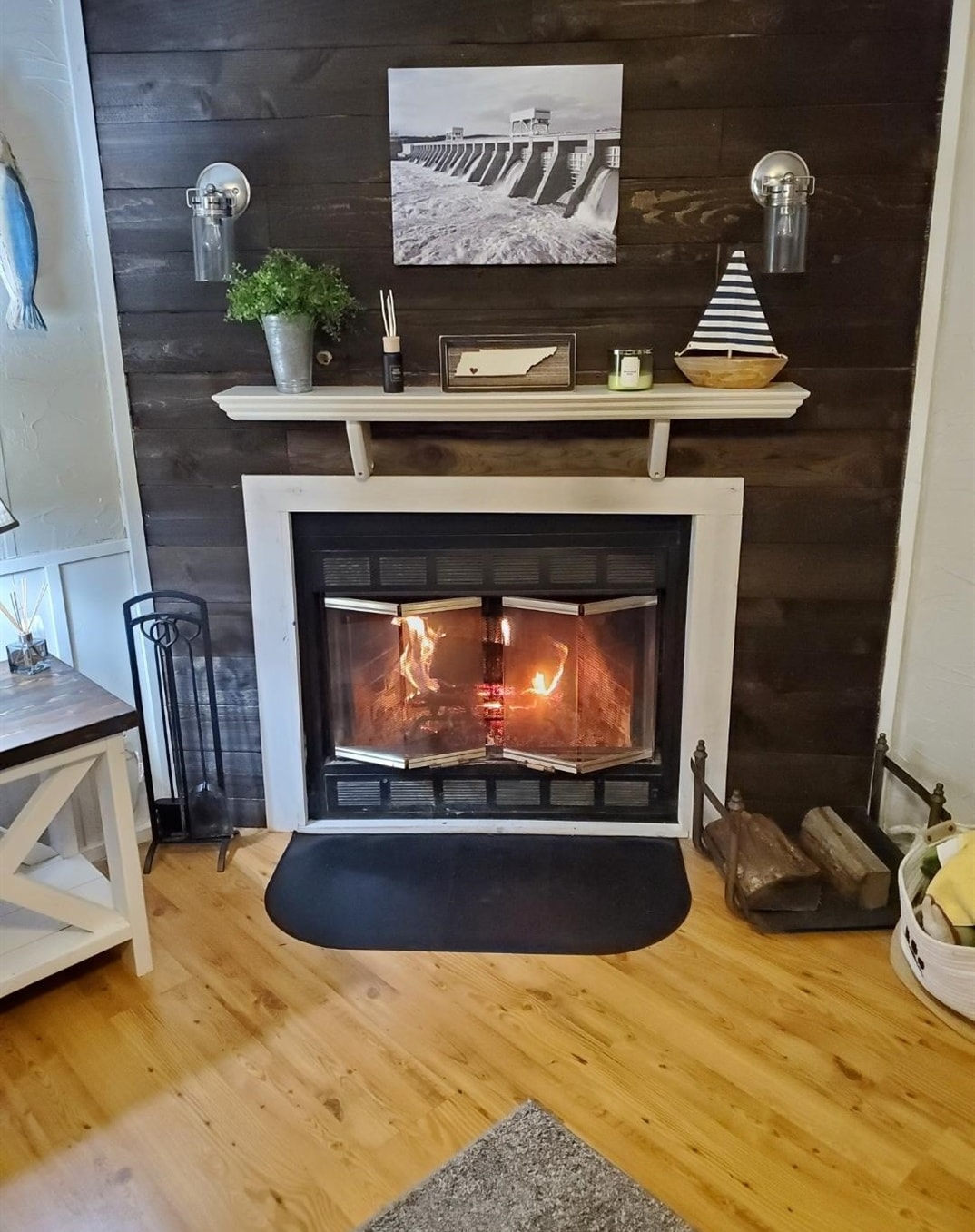 390 Wharf Road Savannah, TN 38372 - Photo 15 of 17 Fireplace featuring a white mantel, dark wood-finish paneling, and two wall sconces