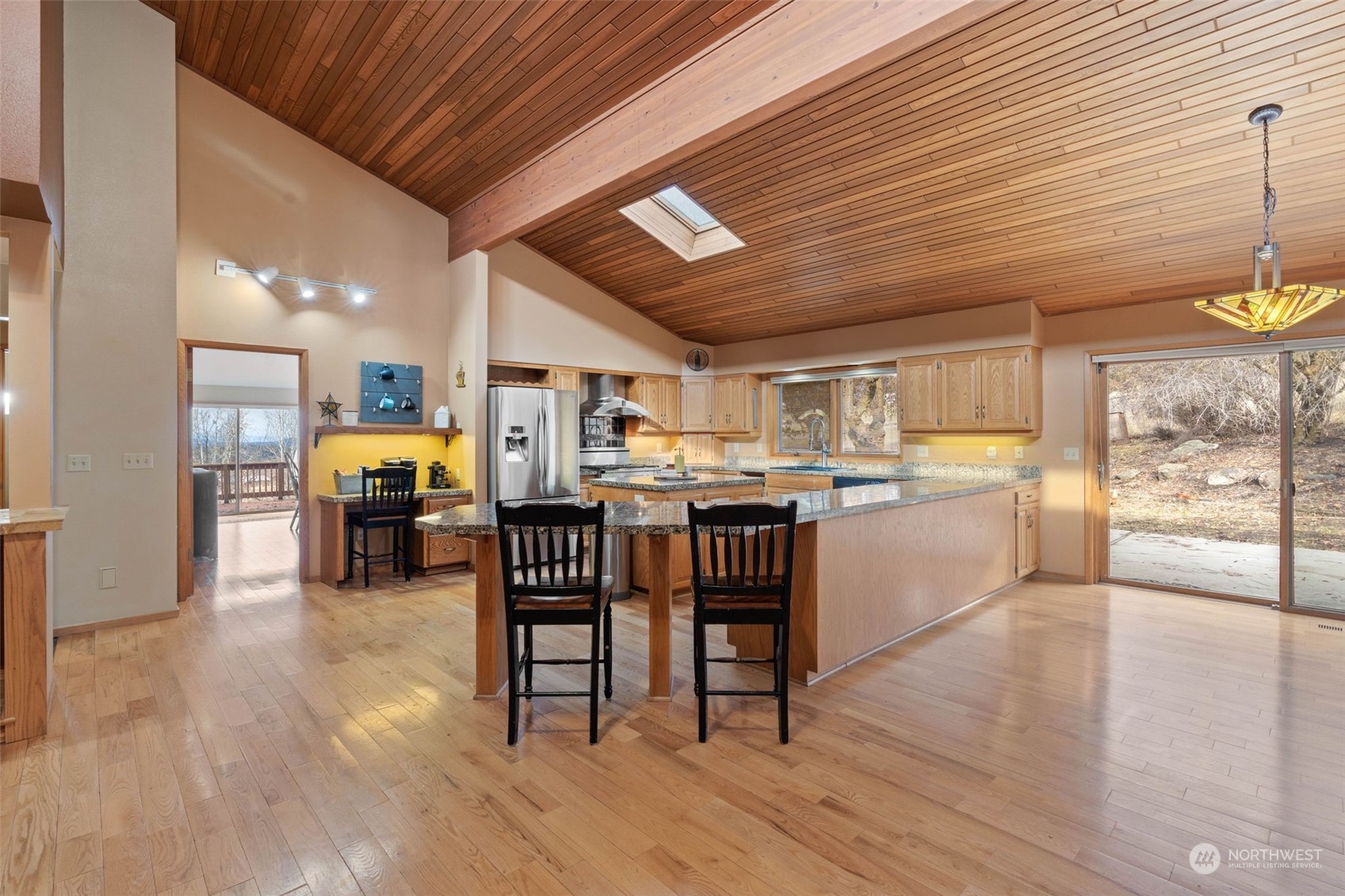 4209 South Eastern Road Spokane, WA 99223 - Photo 13 of 40 a open kitchen with stainless steel appliances kitchen island granite countertop a table chairs and a refrigerator