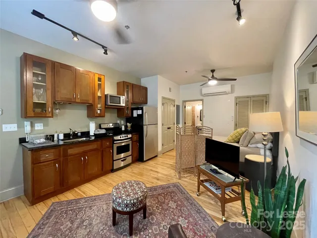 a large kitchen with stainless steel appliances granite countertop a stove refrigerator and a sink