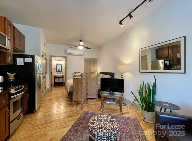 a living room with furniture a window and a flat screen tv