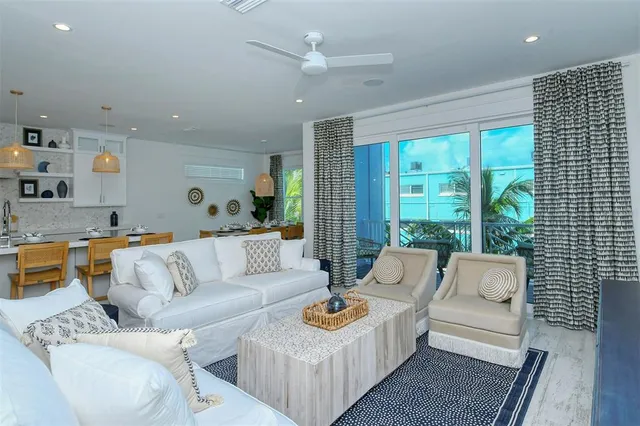 a living room with furniture and a view of kitchen