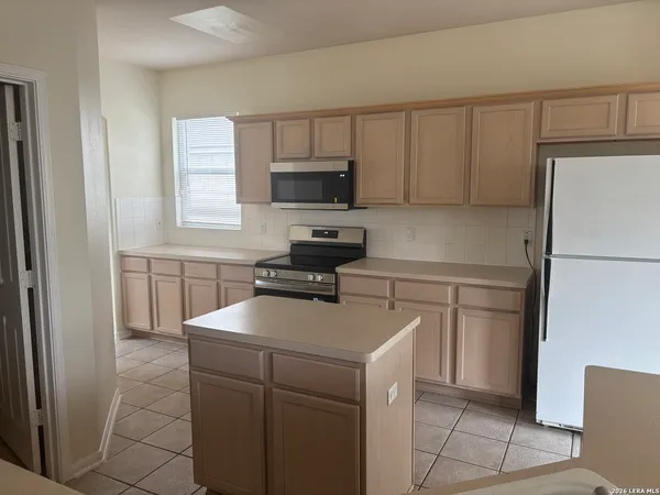 a kitchen with a refrigerator sink and cabinets