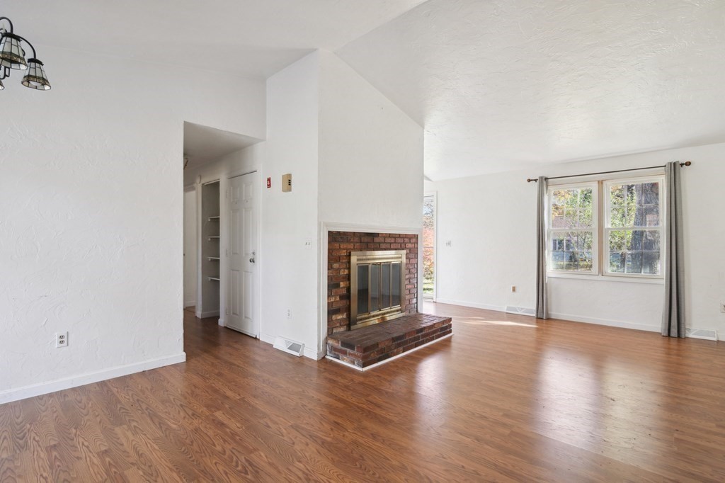 521 Lincoln Rd Extension Hyannis, MA 02601 - Photo 3 of 17 an empty room with wooden floor fireplace and windows