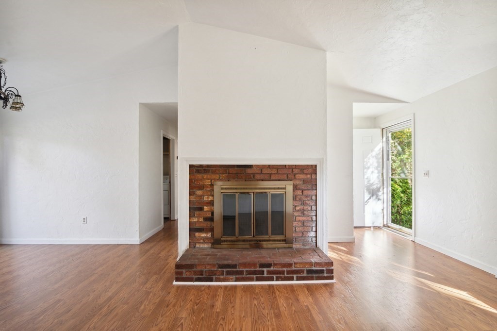 521 Lincoln Rd Extension Hyannis, MA 02601 - Photo 4 of 17 an empty room with wooden floor a fireplace and windows