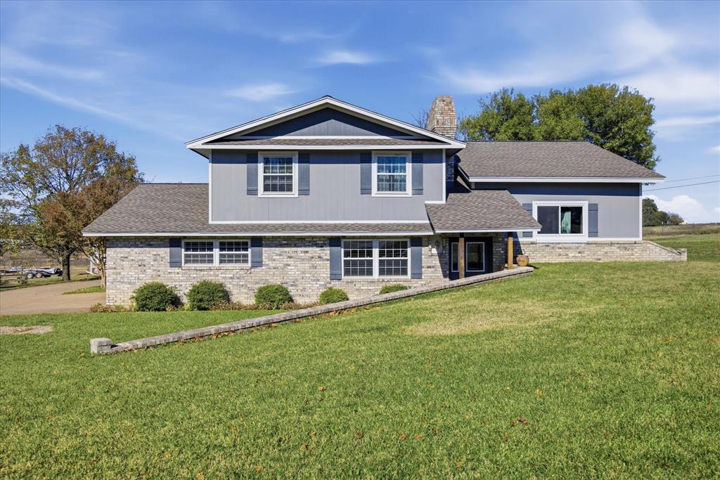 a front view of a house with a garden and trees