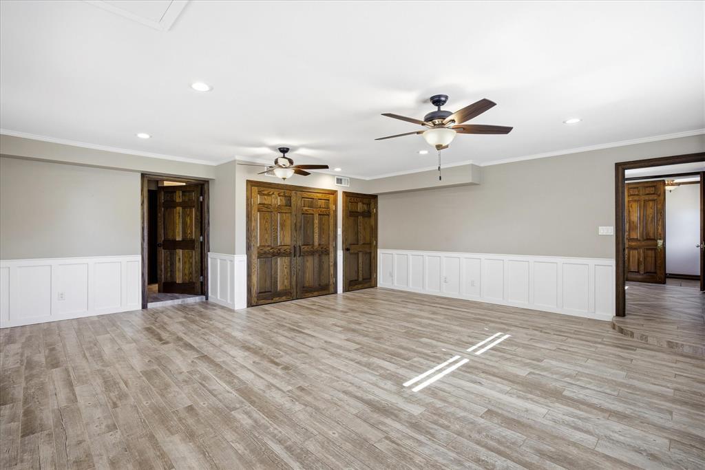 424 Edwards Drive Dublin, TX 76446 - Photo 19 of 40 Unfurnished master bedroom with wainscoting, recessed lighting, light wood-style flooring, crown molding, and ceiling fans