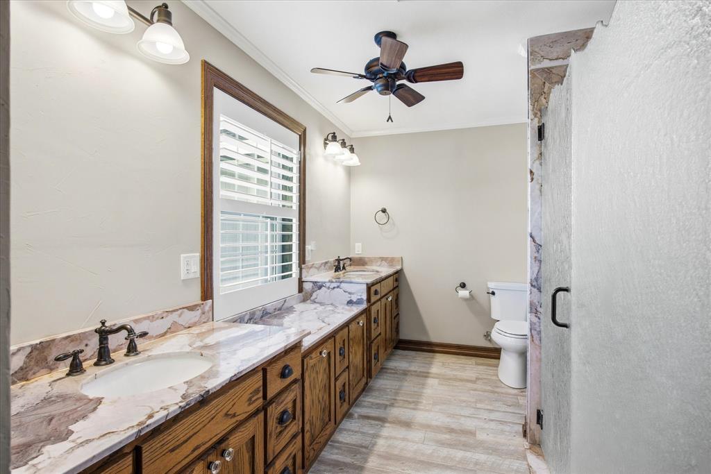 424 Edwards Drive Dublin, TX 76446 - Photo 21 of 40 a spacious bathroom with a granite countertop sink a mirror and a toilet