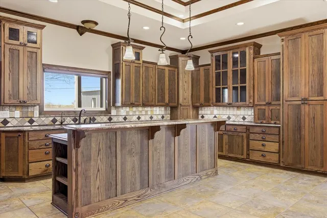 a kitchen with kitchen island granite countertop a sink stove and refrigerator