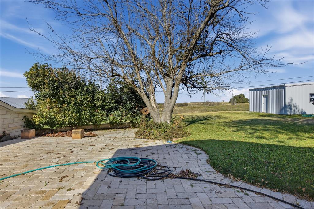 424 Edwards Drive Dublin, TX 76446 - Photo 32 of 40 View of grassy yard featuring a patio area and an outbuilding