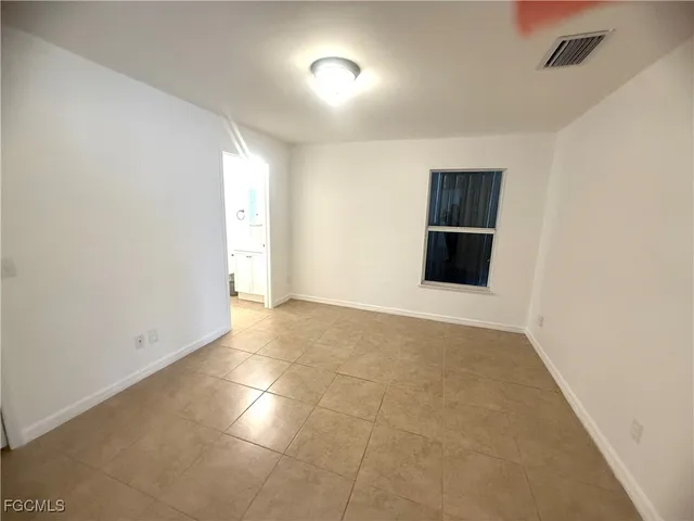 an empty room with closet and windows