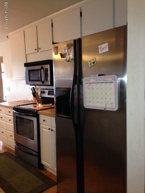 1602 Stein Road Yakima, WA 98908 - Photo 17 of 19 a kitchen with stainless steel appliances granite countertop a refrigerator a stove and a sink with wooden floor