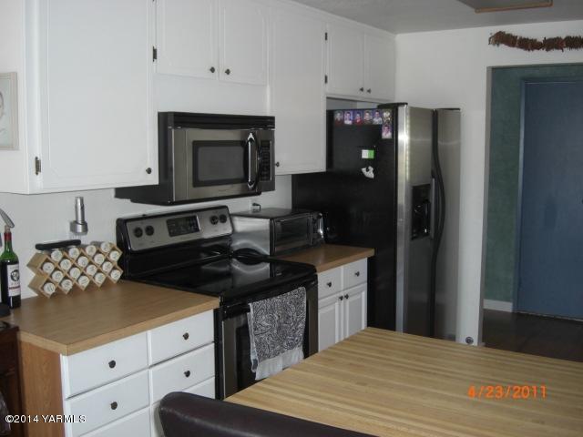 1602 Stein Road Yakima, WA 98908 - Photo 6 of 19 a kitchen with a refrigerator and cabinets