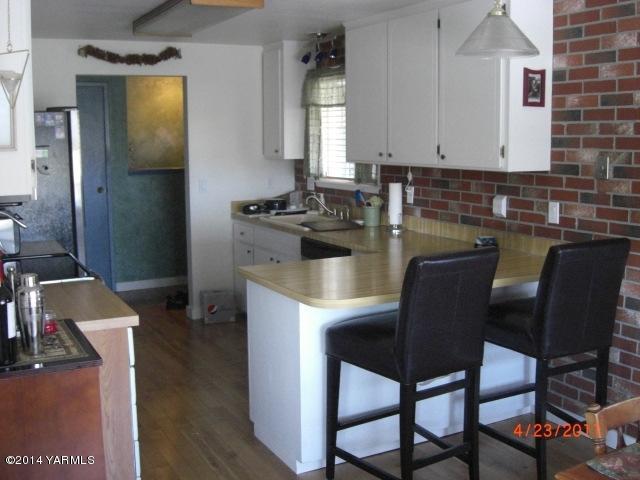 1602 Stein Road Yakima, WA 98908 - Photo 7 of 19 a kitchen with a chair a stove a table and chairs