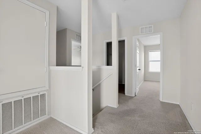 a view of hallway with stairs and a white door
