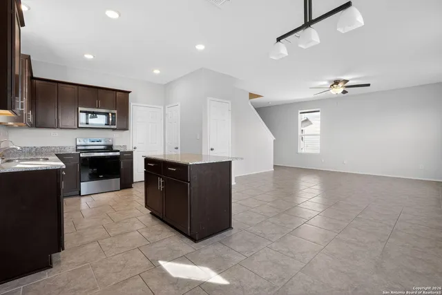 a kitchen with stainless steel appliances granite countertop a stove a sink and a microwave