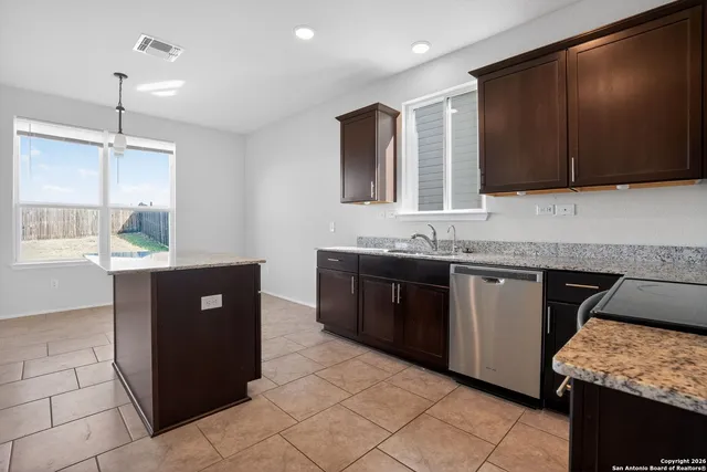 a kitchen with stainless steel appliances granite countertop a refrigerator and a sink